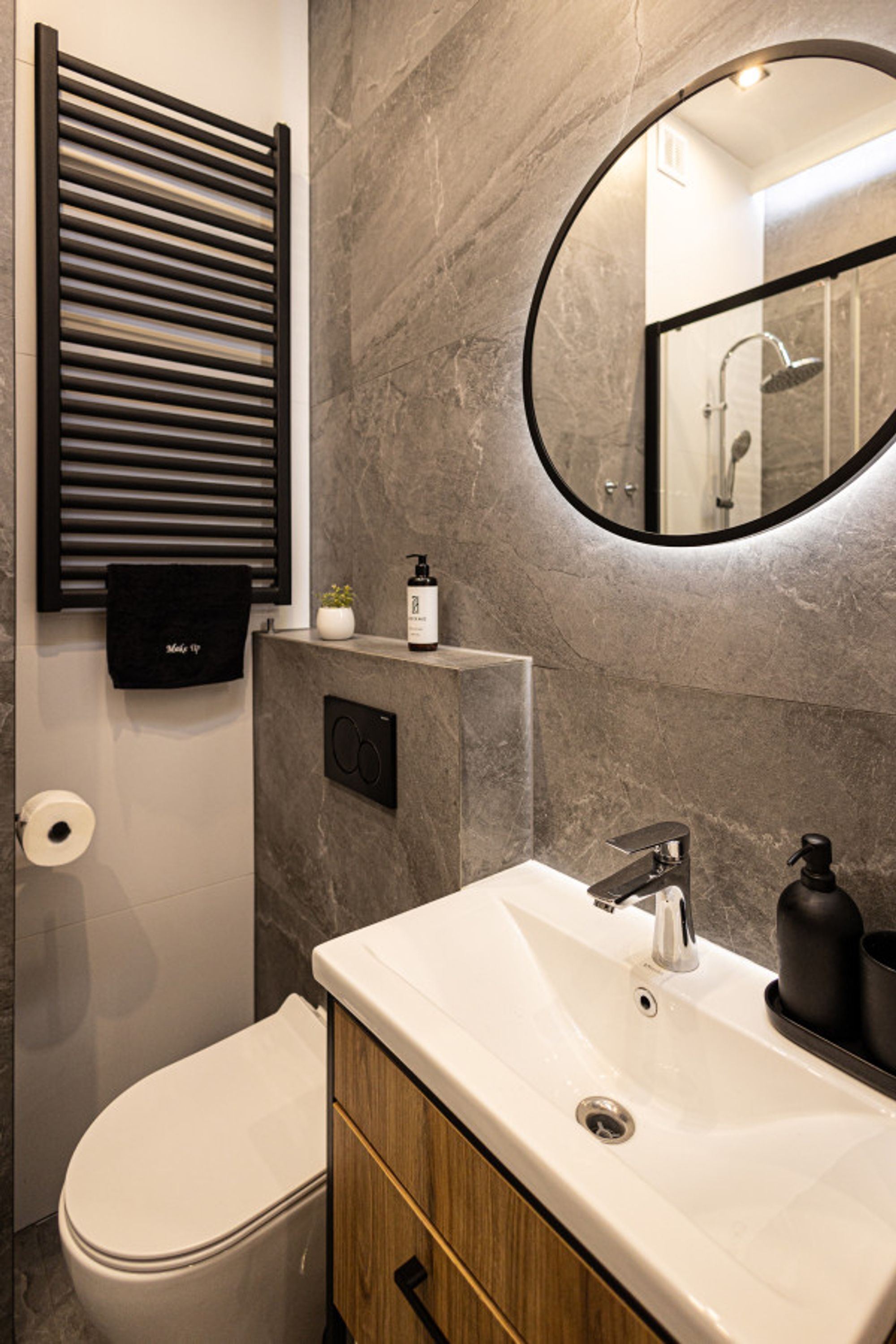 A modern bathroom with a toilet, sink, and mirror.