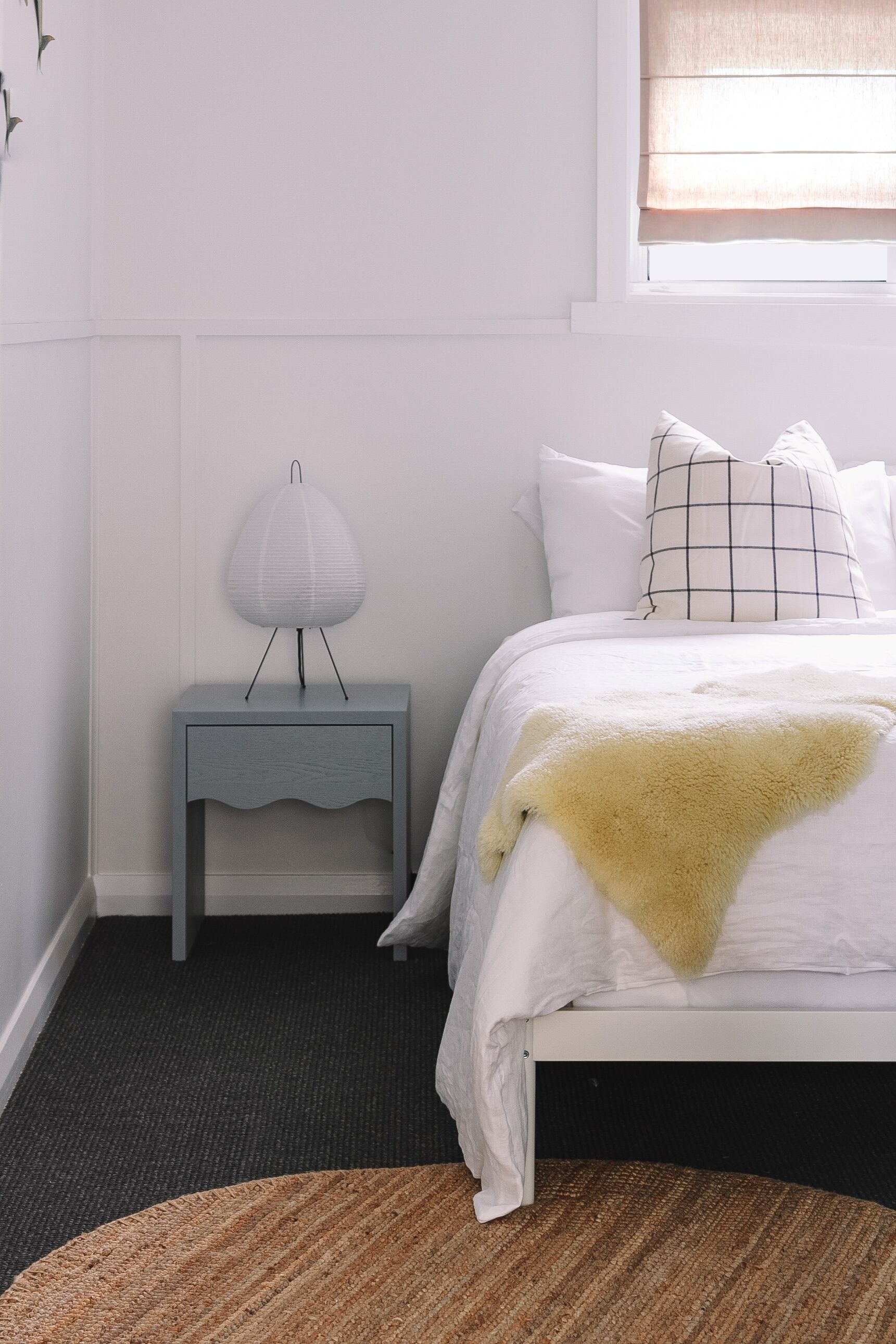 Une chambre à coucher avec un lit, une table de chevet avec une lampe et un tapis.