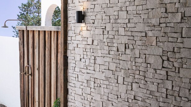 A stone wall with a wooden gate and a small potted plant. - Bay Properties . Our Place (Yamba)