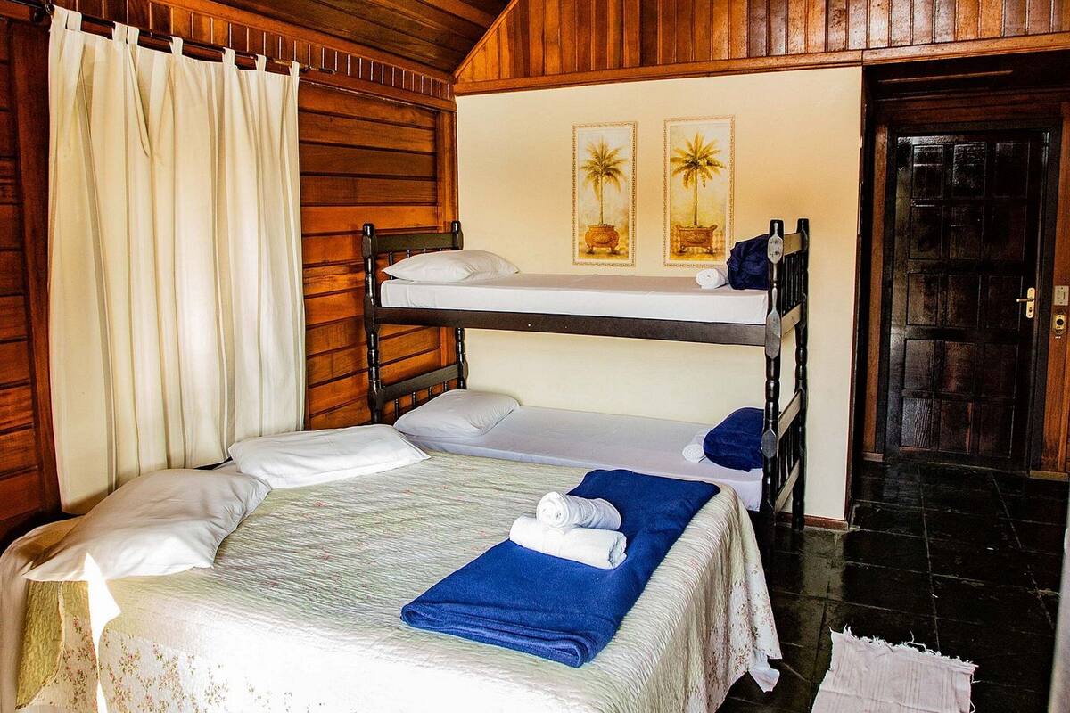 A room with bunk beds, a ceiling fan, and a door.
