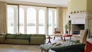 A spacious living room with a sofa, a bed, and a fireplace. - Manor House at La Roche Estate - Franschhoek (Franschhoek)