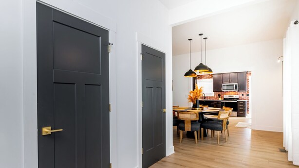 Una cocina moderna con armarios oscuros, una isla central e iluminación colgante.