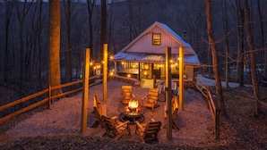A rustic cabin with a fire pit, seating, and string lights in a wooded area. - New Amish built cabin opening up March 14, 2025 near Hocking Hills/Tar Hollow St.Forest (Londonderry)