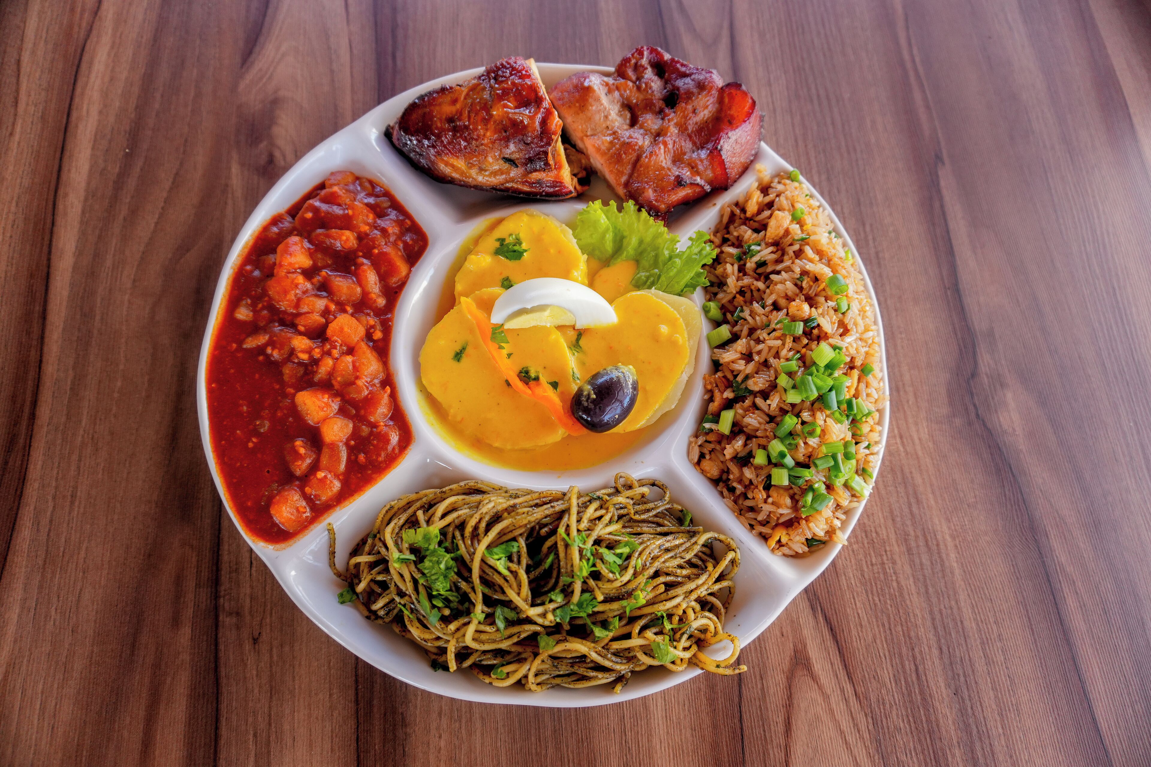A plate of food with various dishes including rice, beans, and meat.