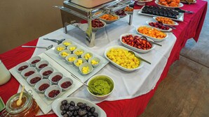 A buffet table with various food items including fruits, vegetables, and dips. - EL PARAISO ECO RESORT (San Andrés)