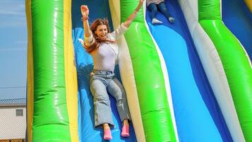 Un tobogán inflable con colores verde y azul y una parte superior de malla.