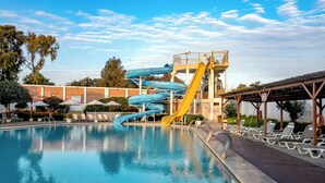 A swimming pool with a water slide, lounge chairs, and a covered area. - EL PARAISO ECO RESORT (San Andrés)