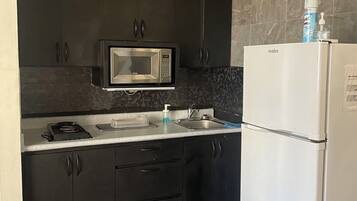 Fridge, microwave, coffee/tea maker, cookware/dishes/utensils