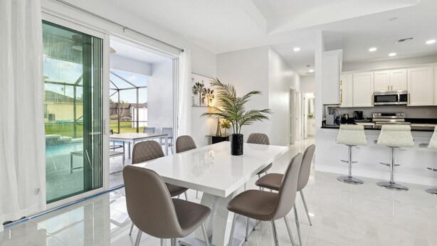 A modern kitchen with white cabinets, stainless steel appliances, and a large island.