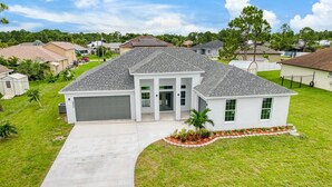 A single-story house with a garage, a covered porch, and a well-maintained lawn.