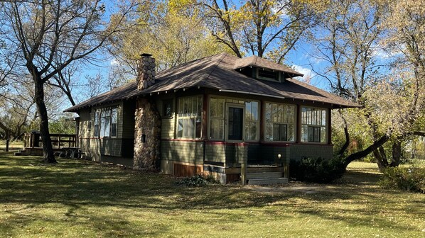 Surrounded by mature trees, this charming single-story building offers a welcoming atmosphere with large windows and a cozy front porch.
