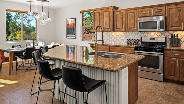 A modern kitchen with granite countertops, stainless steel appliances, and wooden cabinets. - Stylish West Sedona Oasis. Hot Tub, E-BIKES & Kids Play Area (Sedona)