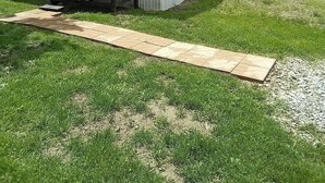 Una casa móvil de dos pisos con un porche cubierto y una pequeña terraza.