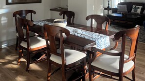 A dining area with a wooden table, chairs, and a chandelier.