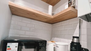 A kitchen with a microwave, coffee maker, and a water bottle.