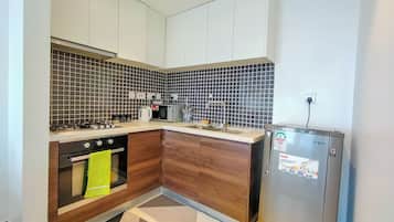 Apartamento Deluxe, balcón, vistas a la ciudad | Cocina privada | Frigorífico, microondas, utensilios de cocina y mesa de comedor