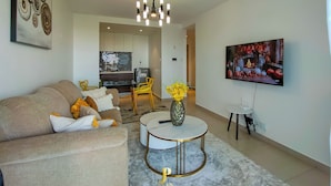 Ein modernes Wohnzimmer mit einer Couch, einem Couchtisch, einem Fernseher und einem Kamin.
