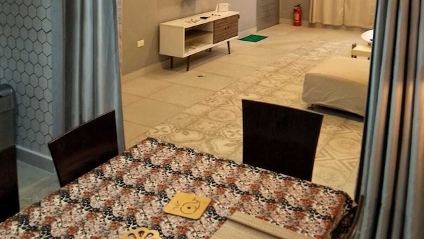 Une chambre d’hôtel avec un coin repas, une télévision et un lit.