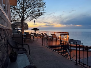 Une terrasse en bord de mer avec des sièges d’extérieur, un mur en pierre et une vue sur l’océan.