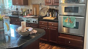 Uma cozinha moderna com armários de madeira escura, um fogão de aço inoxidável e forno duplo.