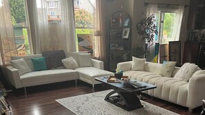 Uma sala de estar ampla com um sofá seccional grande, uma mesa de centro e uma estante.