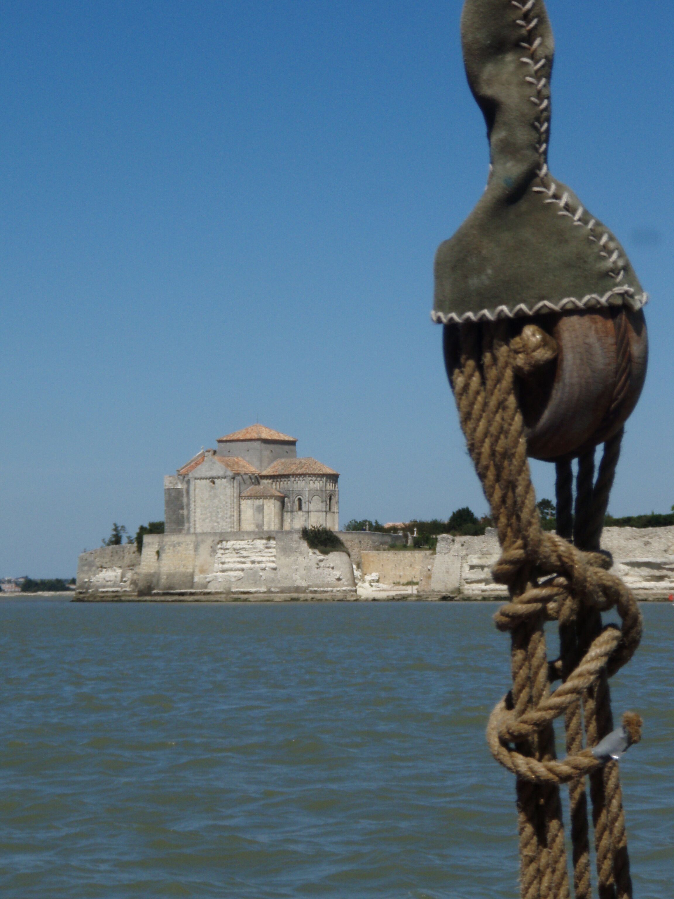 A rope tied around a post with a building in the background.