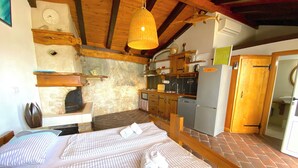 A bedroom with a bed, a wooden headboard, a bedside table, and a wall clock. - house for two with a private terrace located directly on the beach, town Hvar (Hvar)