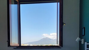 Ein Schlafzimmer mit großem Fenster, einem Bett und Bergblick.