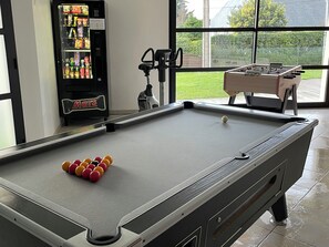 Enjoy a game of pool with a view of the backyard from this room's large window.