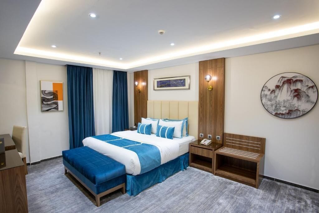 Una camera d'hotel con un letto grande, comodini, una scrivania e una sedia.