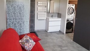 A modern bathroom with a white sink, mirror, and a washing machine. - House for 6 people ideally located, close to many leisure activities (La Chapelle-Huon)