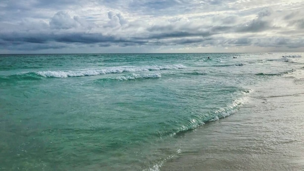 A beach with turquoise waters and a cloudy sky. - Stay a While - 3 min walk to private beach access!

 (Destin)