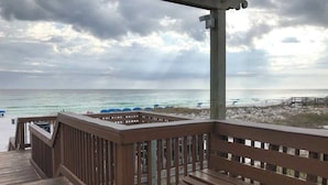 A wooden deck with a bench overlooking a beach with umbrellas and a sandy area. - Stay a While - 3 min walk to private beach access!

 (Destin)