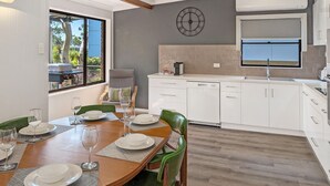 A modern kitchen with white cabinets, a built-in oven, and a window above the sink.
