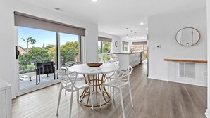 Una cocina moderna con armarios blancos, encimera de madera y un amplio ventanal con vistas a la ciudad.