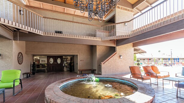A courtyard with a central fountain, outdoor seating, and a reception area. - Recliners! Large Az Room - Adult 55+ Activities Galore! (Mesa)