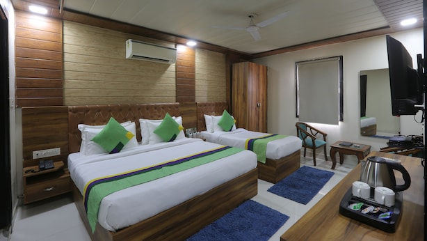 A hotel room with two beds, a desk, a chair, a coffee maker, and a TV. - hotel hi life DX (New Delhi)