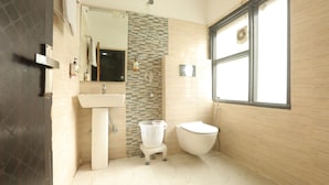 A bathroom with a toilet, sink, and window. - hotel hi life DX (New Delhi)