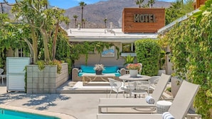 Ein Motel mit Außenbestuhlung, einem Pool und Blick auf die Berge.