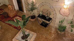 Una sala de estar acogedora con chimenea, plantas en macetas y un conjunto de asientos cómodos.