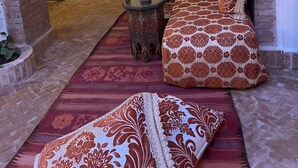 Un interior acogedor con un sofá estampado, una mesa decorativa y una alfombra.
