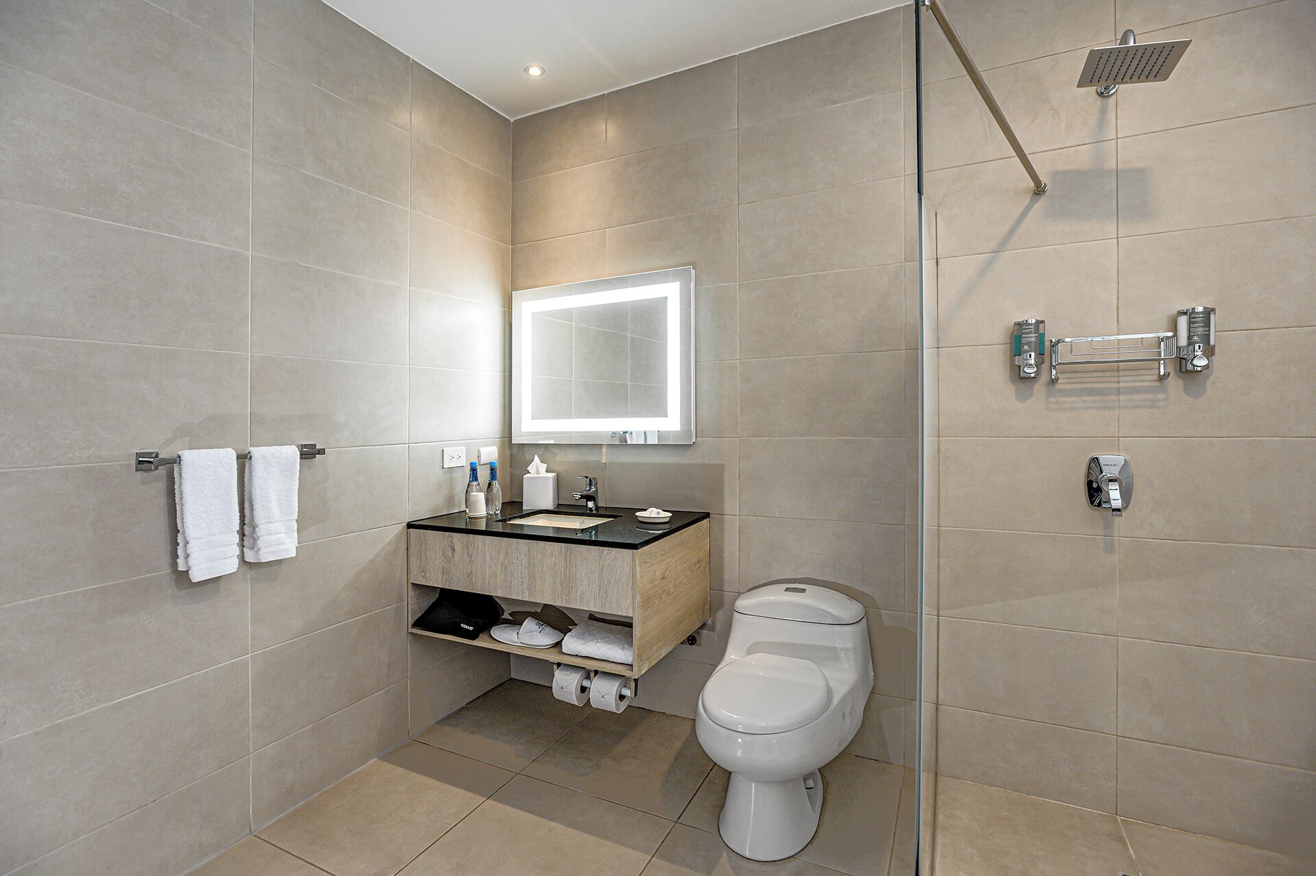 A modern bathroom with a toilet, sink, mirror, and shower.