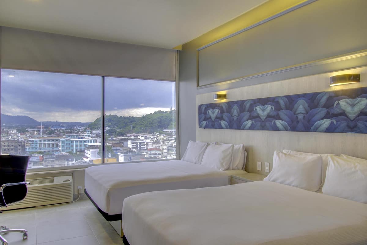 Ein Hotelzimmer mit zwei Betten, einem großen Fenster und Blick auf die Stadt, sowie modernem Design.