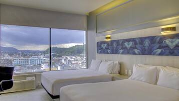 Quarto de hotel com duas camas, uma janela grande com vista para a cidade e design moderno.