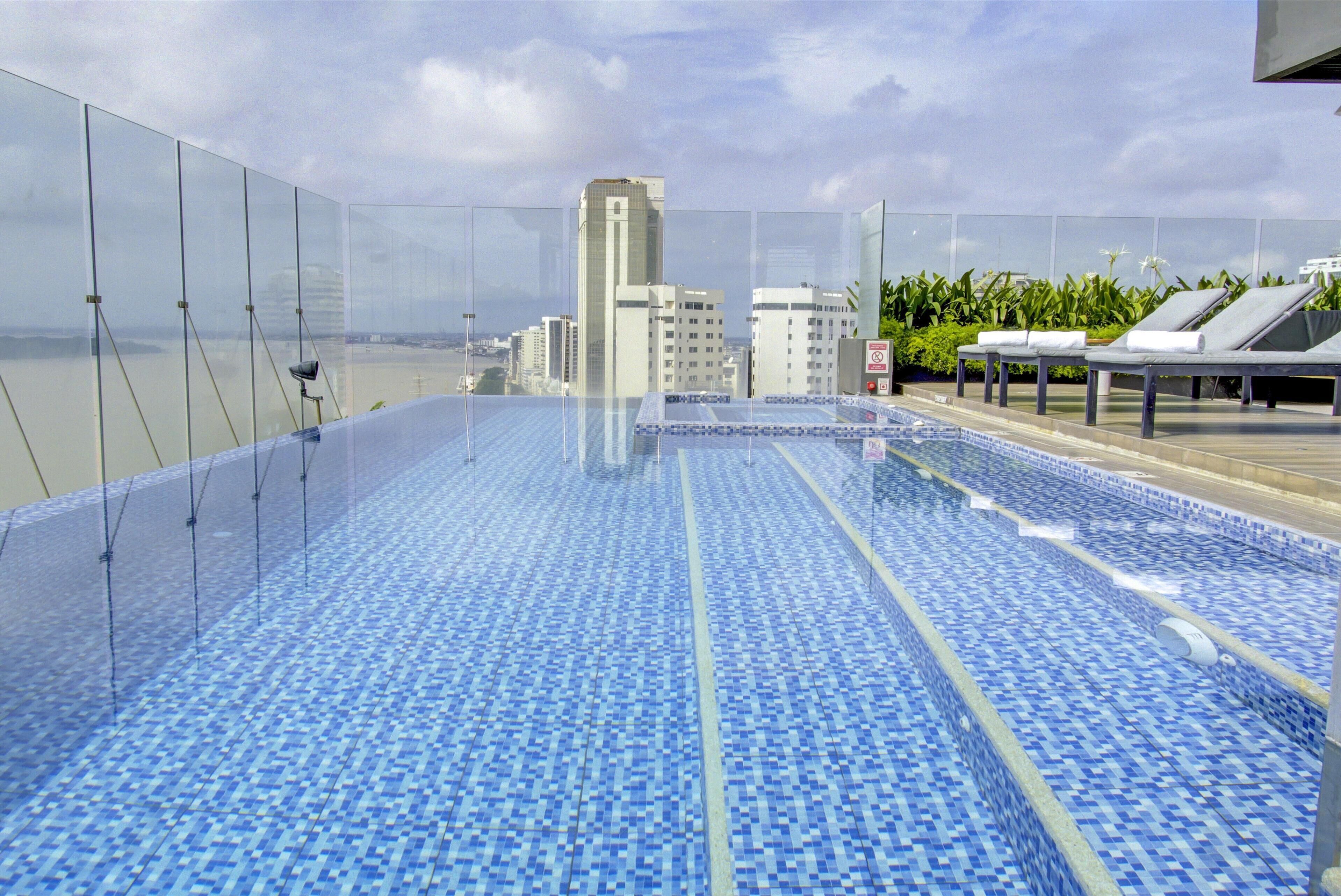 Una piscina infinita en la azotea con vistas al horizonte de la ciudad.