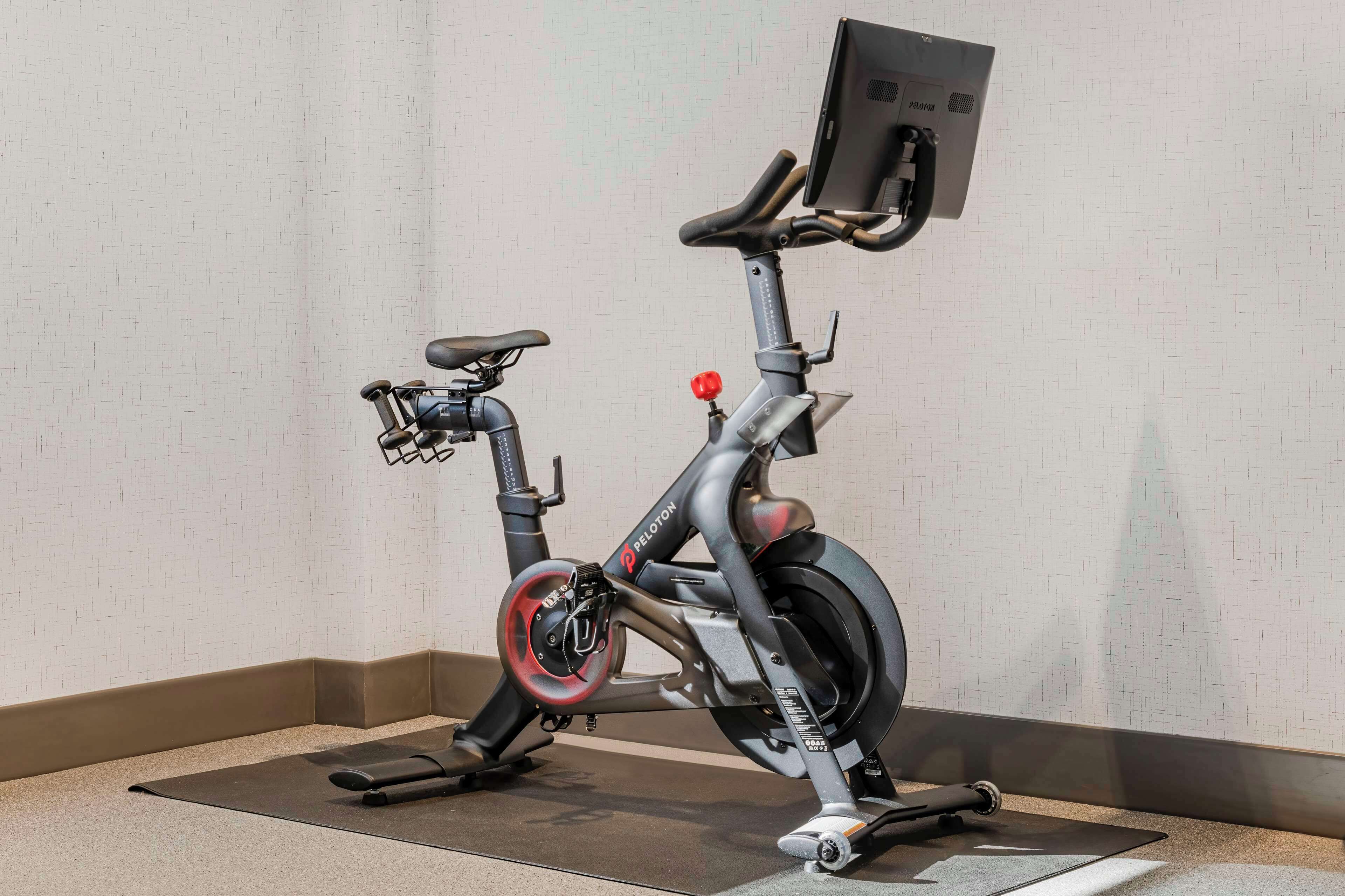 A stationary exercise bike with a digital display and a handlebar.