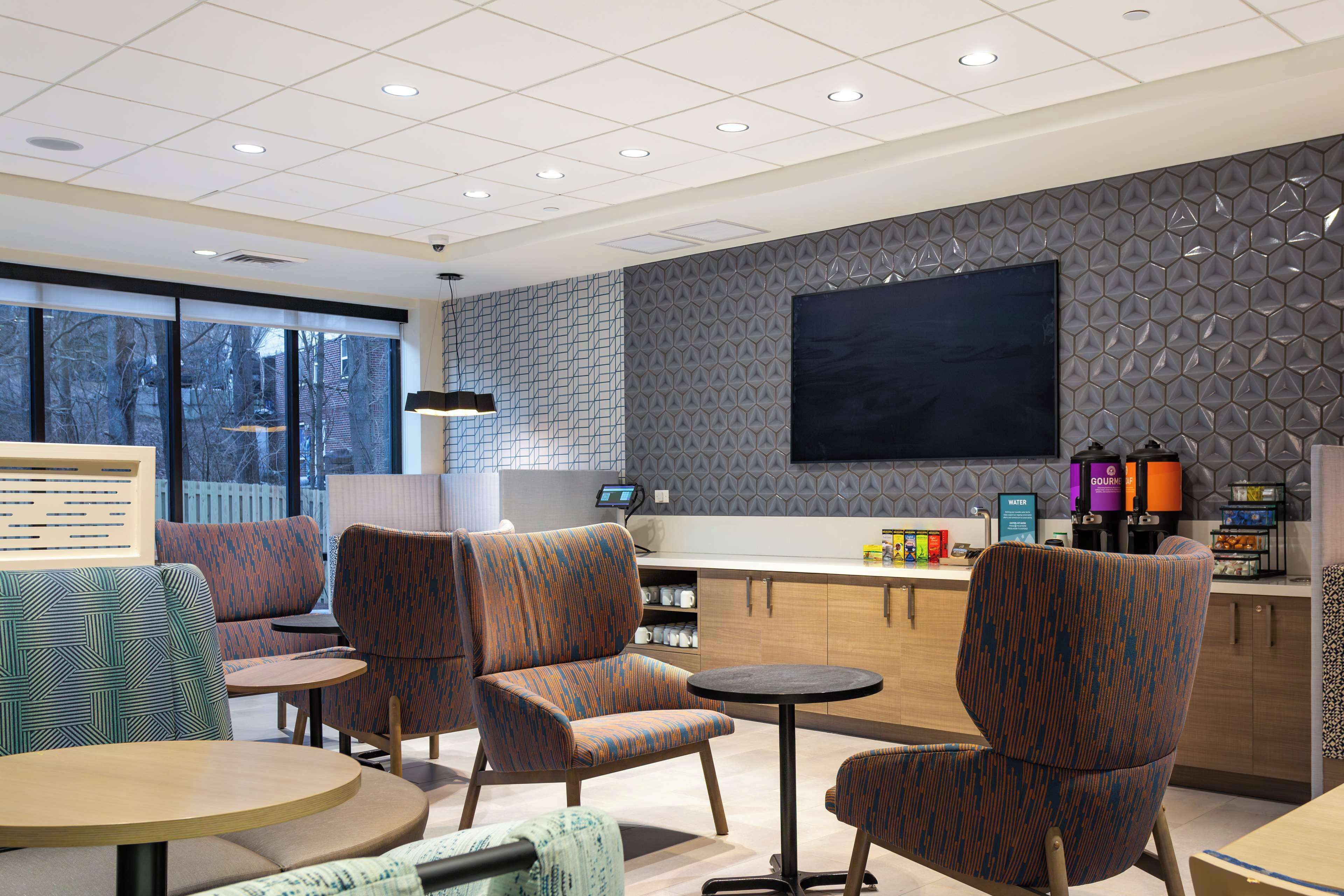 A modern interior with seating, a bar area, and a large flat-screen TV.