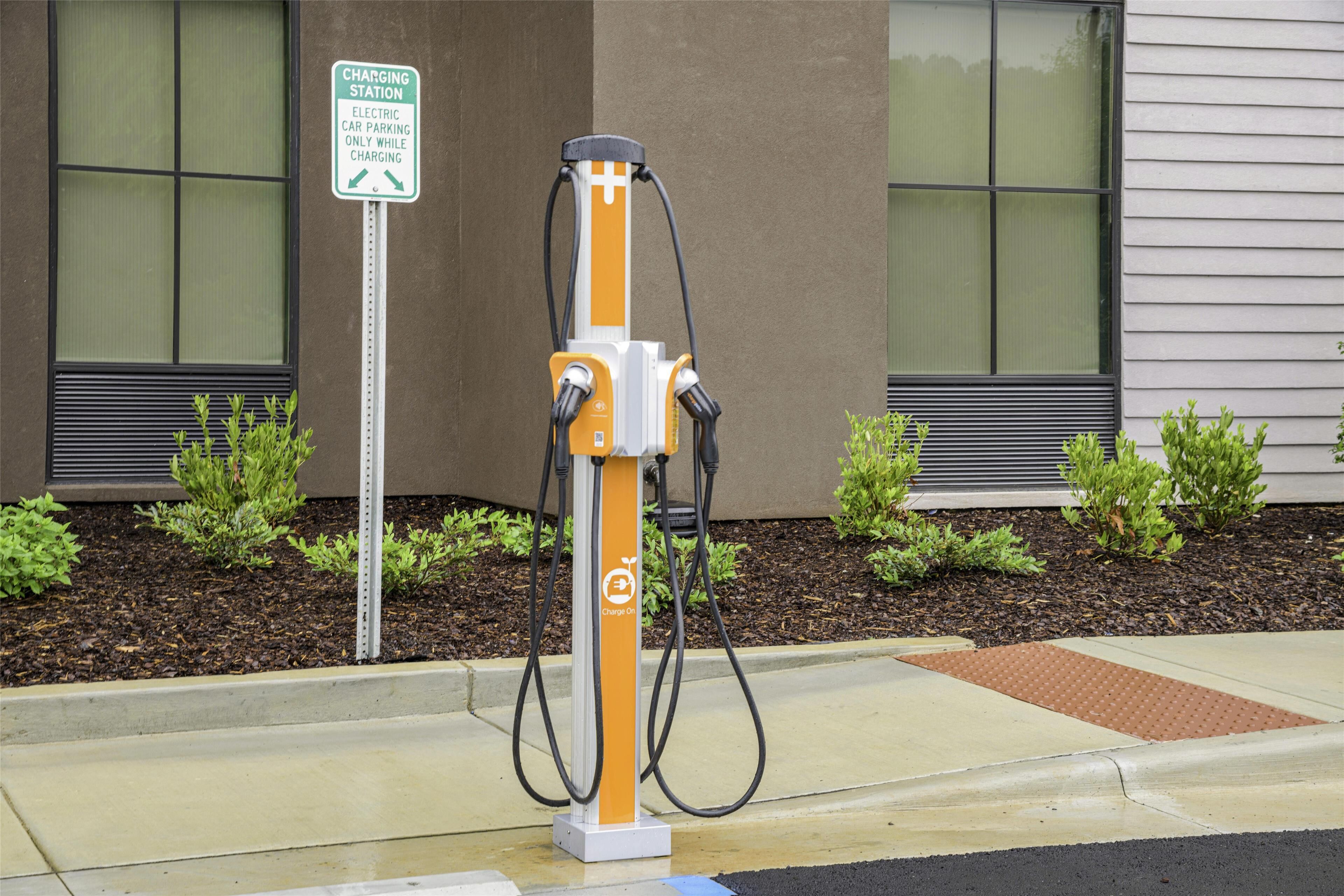 An electric car charging station with a sign indicating it is for electric cars only while charging.