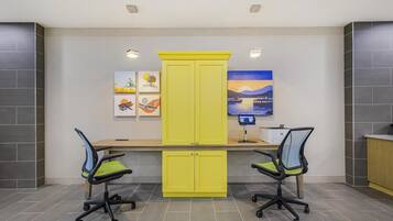 A modern office space with two desks, yellow cabinets, and office chairs.