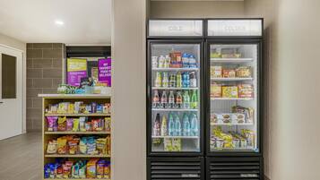 A refrigerated display with snacks and beverages, including a variety of chips, cereals, and bottled drinks.